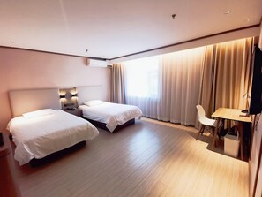 A hotel room with two beds, a desk, a chair, and a TV. - Hanting Hotel (Beijing)