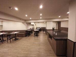 A modern restaurant with booths and tables, wooden flooring, and recessed lighting. - Hanting Hotel (Beijing)