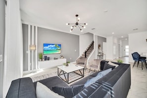 Inviting living area of the townhouse in Kissimmee Florida - Features a comfortable couch and a large flat-screen smart TV - Elegantly decorated space with a neutral color palette for a timeless appeal - Quality fixtures and fittings - Luxe 5BR Townhouse w/ Pool & Mickey-Themed Room (Kissimmee)