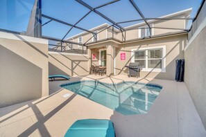 A swimming pool with a glass ceiling, a barbecue area, and a patio with outdoor furniture. - Luxe 5BR Townhouse w/ Pool & Mickey-Themed Room (Kissimmee)