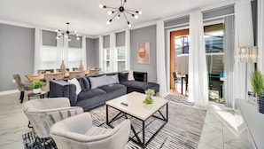A modern living room with a sectional sofa, a coffee table, and a chandelier. - BBQ, Splash Pool & FREE Resort Access! Near WDW. (Kissimmee)