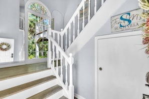 Un escalier avec des rampes blanches et des marches en bois menant à un palier.