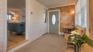 A hallway with a wooden door, a small round table, and a chair. - 3 Mi to Dtwn & Beach! Bristol Home w/ Patio (Bristol)
