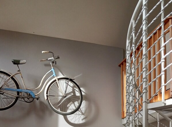Un vélo est accroché à un mur, avec une structure en bois en arrière-plan.