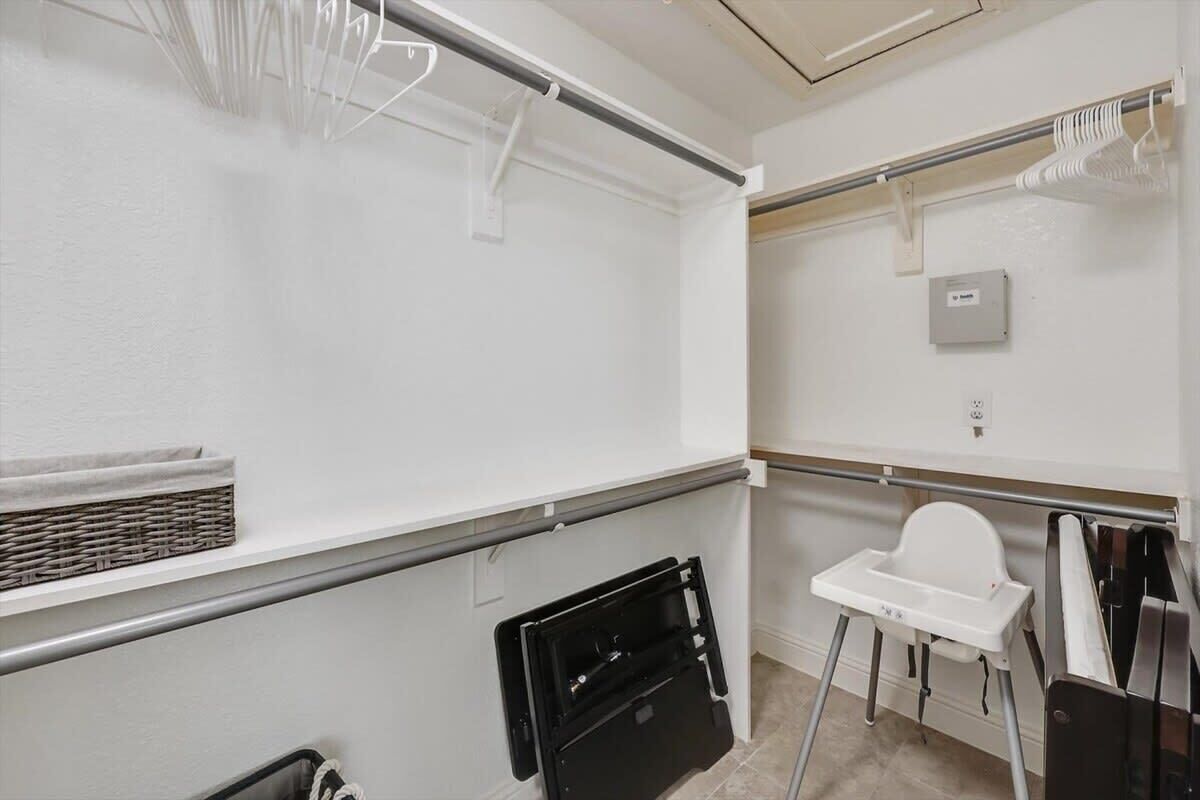 A bathroom with a white sink, a white toilet, a white baby changing station, and a black storage unit.