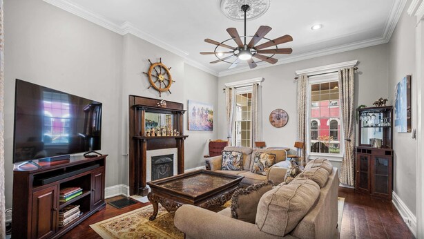 A living room with a television, fireplace, sofa, and ceiling fan. - Game Room, Back Yard, Close to Stadiums & Downtown (Covington)