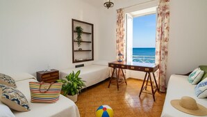 A room with a bed, a desk, a view of the sea, and a beach ball. - Casa Baia Salata 1 (Imperia)