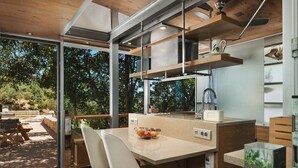 Een moderne keuken met een groot eiland, inbouwapparatuur en uitzicht op de omgeving.