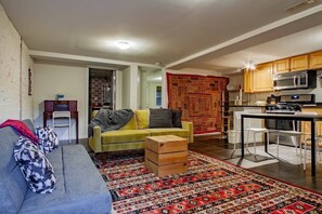 A living room with a sofa, a coffee table, and a patterned rug.