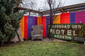 A colorful fence with a sign that reads 'Crossroad Inn Motel Modern.'