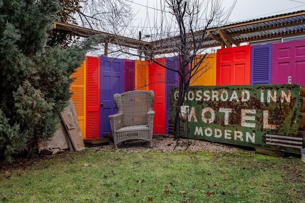 A colorful fence with a sign that reads 'Crossroad Inn Motel Modern.'