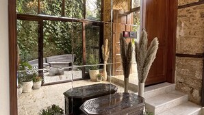 Um interior moderno com uma janela ampla, um lustre e uma parede de pedra.