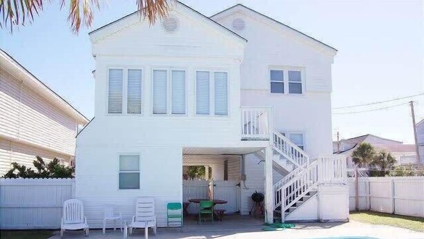 A two-story white house with a front porch, a small outdoor seating area, and a swimming pool. - It'll Do Two -  Private Pool Close to Beach (North Myrtle Beach)