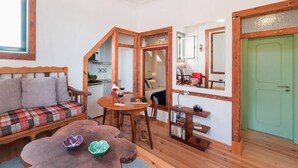 A cozy room with a wooden bench, a dining table, and a green door. - Cozy Apartment in Historical Lisbon by COZYSTAYS 5/5 (Lisbon)