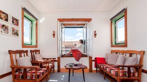 A cozy room with wooden furniture, a table, and a view through an open door. - Cozy Apartment in Historical Lisbon by COZYSTAYS 5/5 (Lisbon)