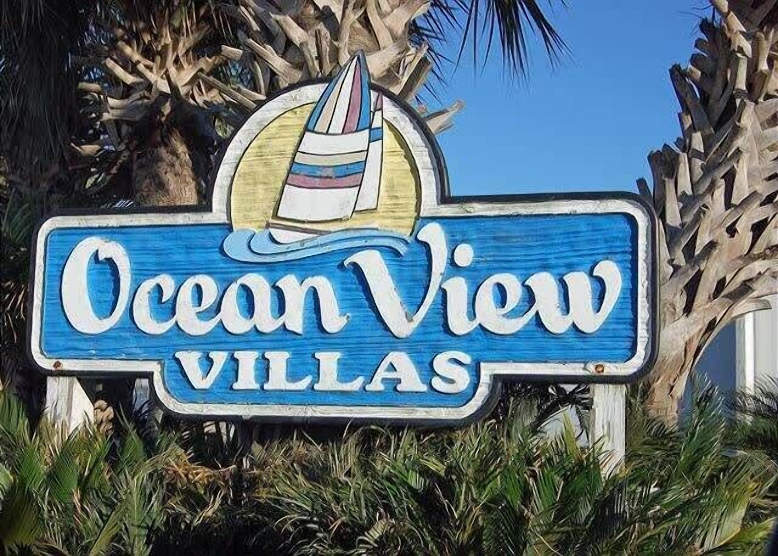 Een bord voor Ocean View Villas, met een logo van een zeilboot.