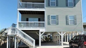 Un bâtiment à deux étages, doté d’un balcon au premier étage et d’un porche couvert.