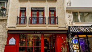 A multi-story hotel with a red entrance, multiple balconies, and a sign for 'La Porte de Taksim'. - La Porte de Taksim (Istanbul)