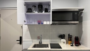 A kitchen with a microwave, a sink, and various utensils. - Bushiri's Long Life Studio w/Kingbed & Balcony #9 (Oranjestad)