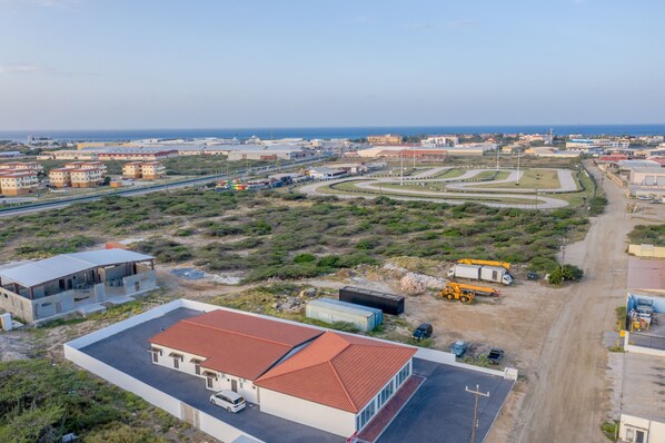 Vue aérienne d’une zone côtière avec des bâtiments, des routes et un chantier de construction.