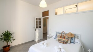 A bedroom with a bed, a potted plant, a hanging light, and a window with a view. - Casa Baia Salata 2 (Imperia)