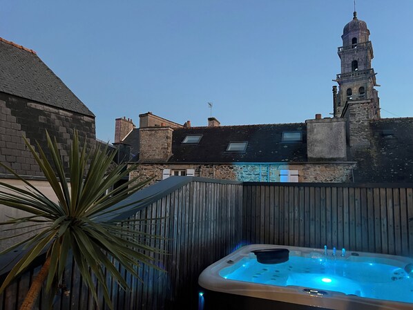 A hot tub in a backyard with a view of a historic building and a tall tower in the background.