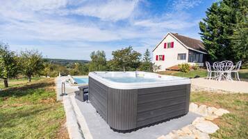 Een bubbelbad in een achtertuin met een huis op de achtergrond.
