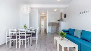 A modern living space with a dining area, a kitchen, and a sofa. - Apartment with swimming pool near sea (Dramalj)