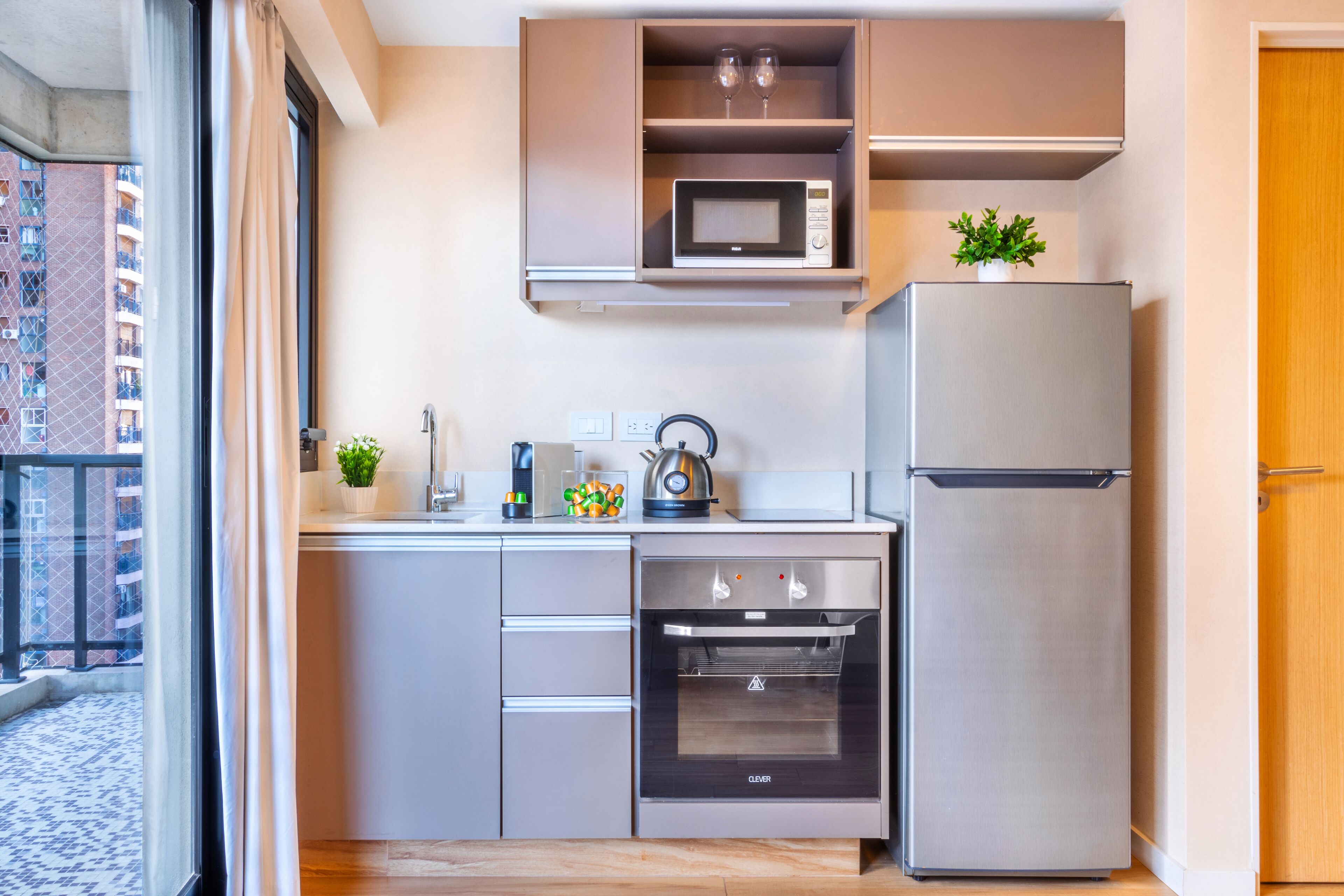 Cocina compacta con microondas, horno y refrigerador integrados.