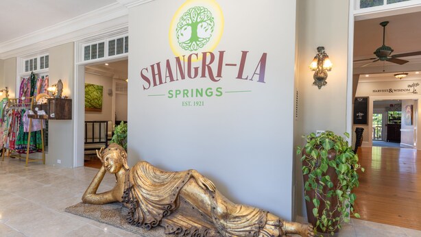 A hotel entrance with a large sign reading "SHANGRI-LA SPRINGS EST. 1921". - Shangri-La Springs (Bonita Springs)
