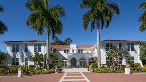 A white building with a red roof, large windows, and a central entrance. - Shangri-La Springs (Bonita Springs)