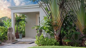 A well-maintained garden with a stone lion statue, a palm tree, and a building with a 'Spa' sign. - Shangri-La Springs (Bonita Springs)