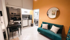 A compact living space with a kitchenette, a dining area, and a sofa. - Charming apartment in the city center (Avignon)