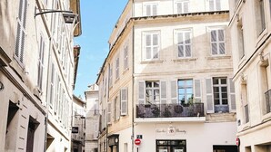 A narrow cobblestone street lined with historic buildings, featuring a boutique hotel with a ground-floor salon. - Charming apartment in the city center (Avignon)