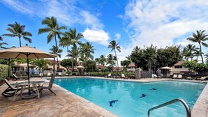 A swimming pool with lounge chairs and umbrellas, surrounded by palm trees and a clear sky. - KKSR#8301 AMAZING 3 BEDR, TOP FLOOR CORNER UNIT: REMODELED, AIR CONDITIONING (Kailua Kona)