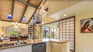 A kitchen with a central island, a dishwasher, and a spiral staircase. - KKSR#8301 AMAZING 3 BEDR, TOP FLOOR CORNER UNIT: REMODELED, AIR CONDITIONING (Kailua Kona)