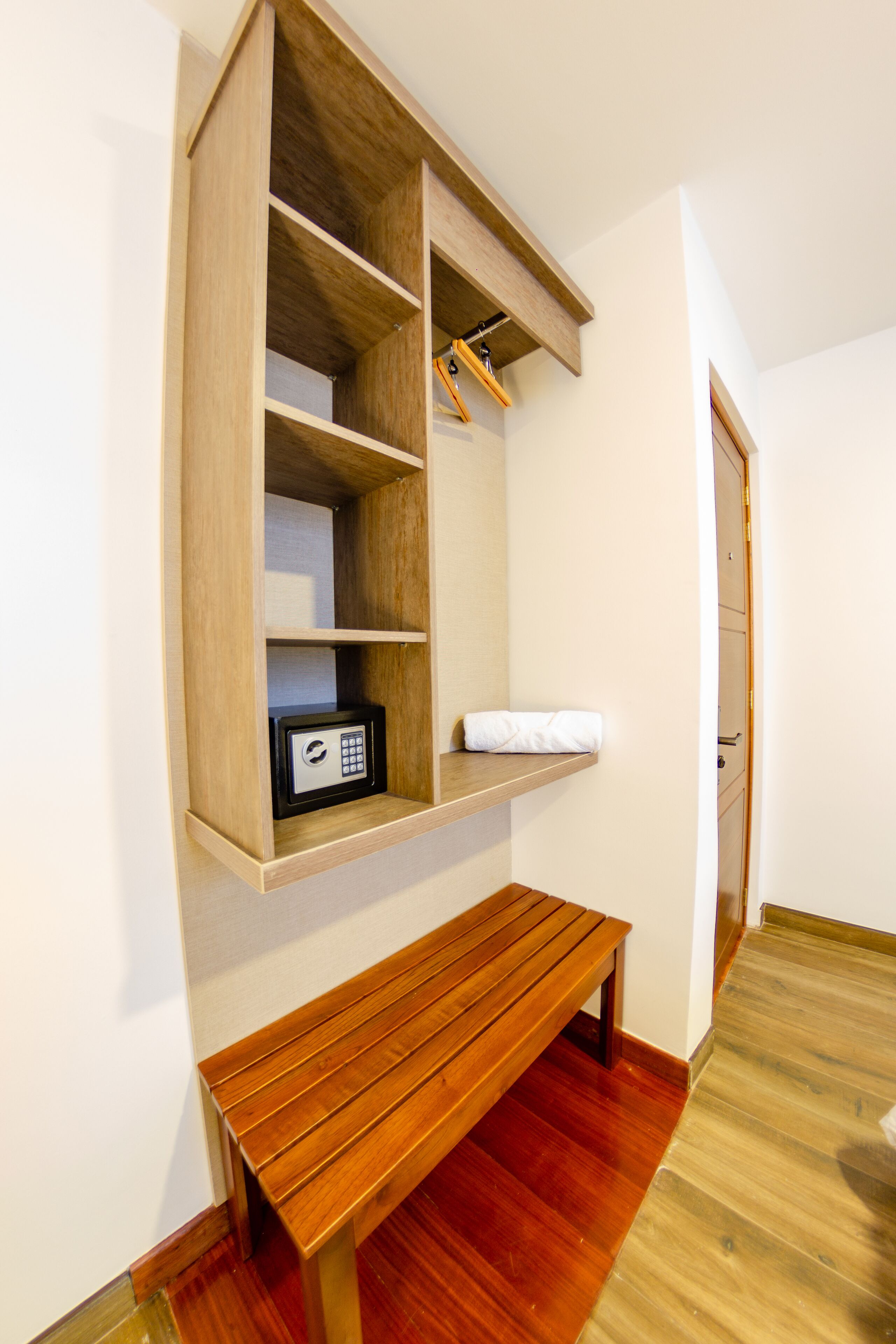 Un banco de madera y un estante empotrado con una caja fuerte.