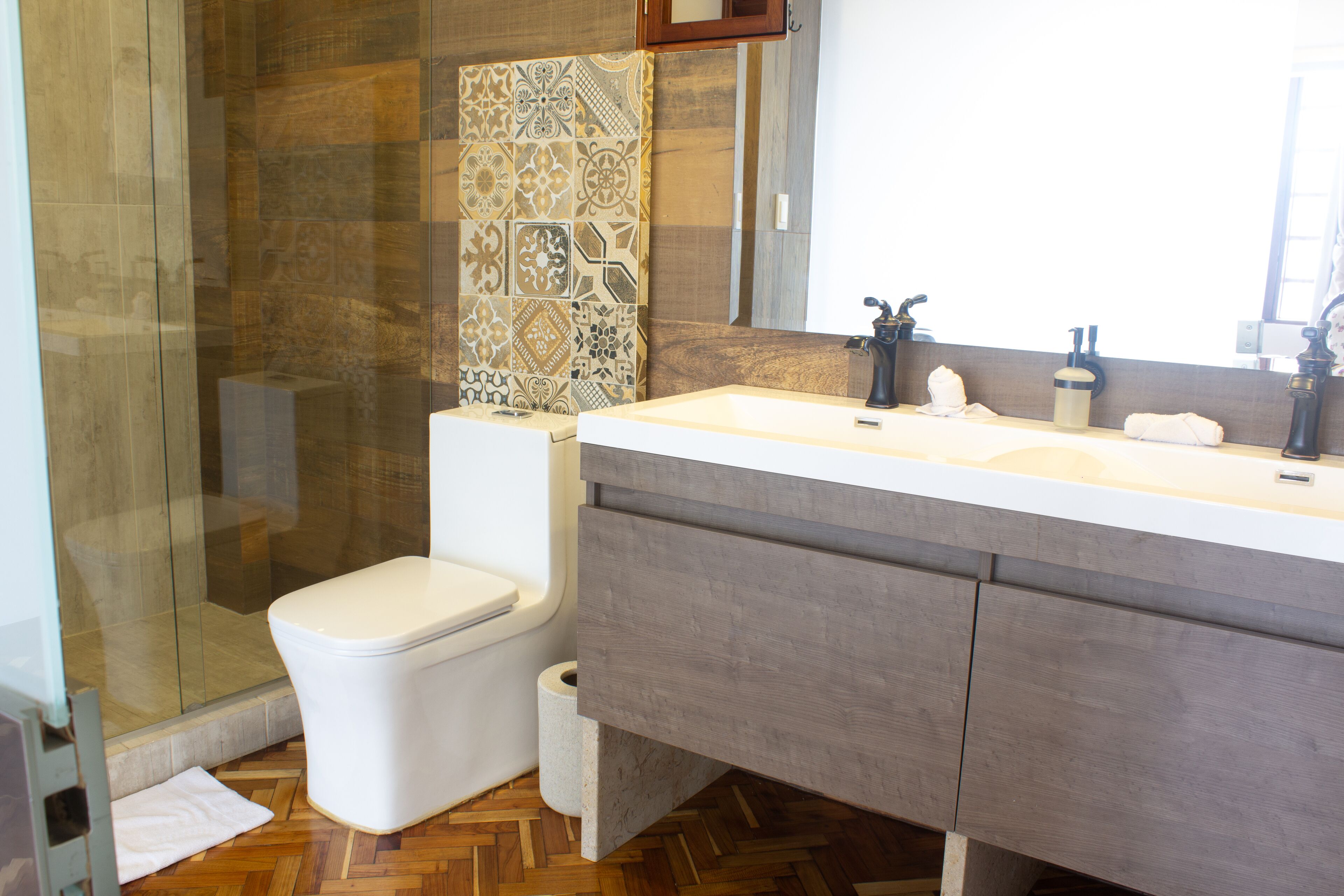 Une salle de bain moderne équipée d’une douche, de toilettes et d’un meuble-lavabo.