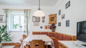 A cozy dining area with a wooden table, chairs, and a bench. - Apartment Kitzbuhel near Ski Slopes (Kitzbühel)