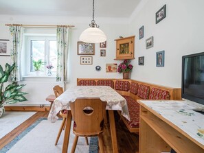 A cozy dining area with a wooden table, chairs, and a bench. - Apartment Kitzbuhel near Ski Slopes (Kitzbühel)