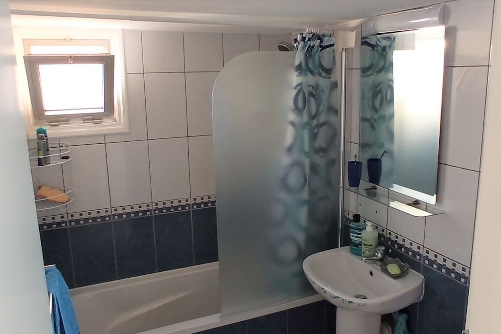 Tina con regadera, secadora de cabello, toallas 