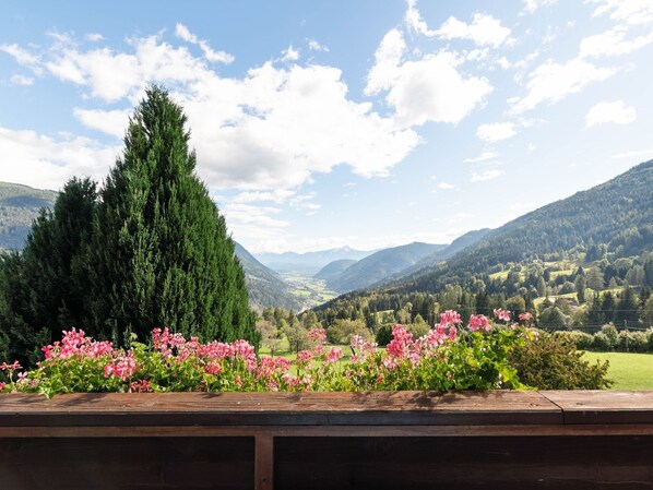 A scenic view of a mountainous landscape with a wooden bench in the foreground.