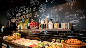 Ein Buffetbereich mit verschiedenen Speisen und einer Tafel mit motivierenden Sprüchen.