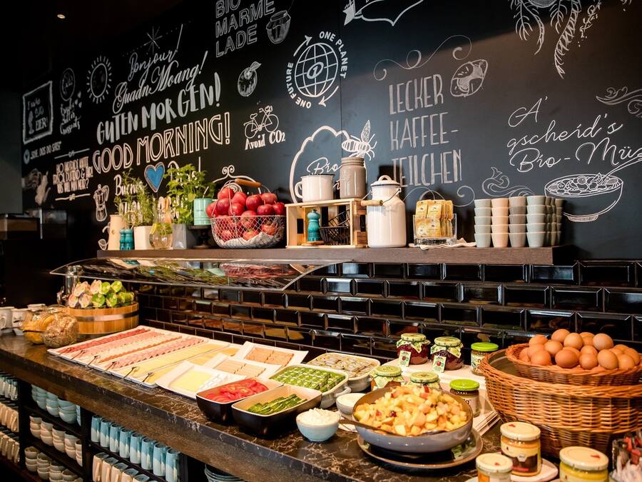 Zona de bufé con diferentes opciones de comida y una pizarra con mensajes inspiradores.