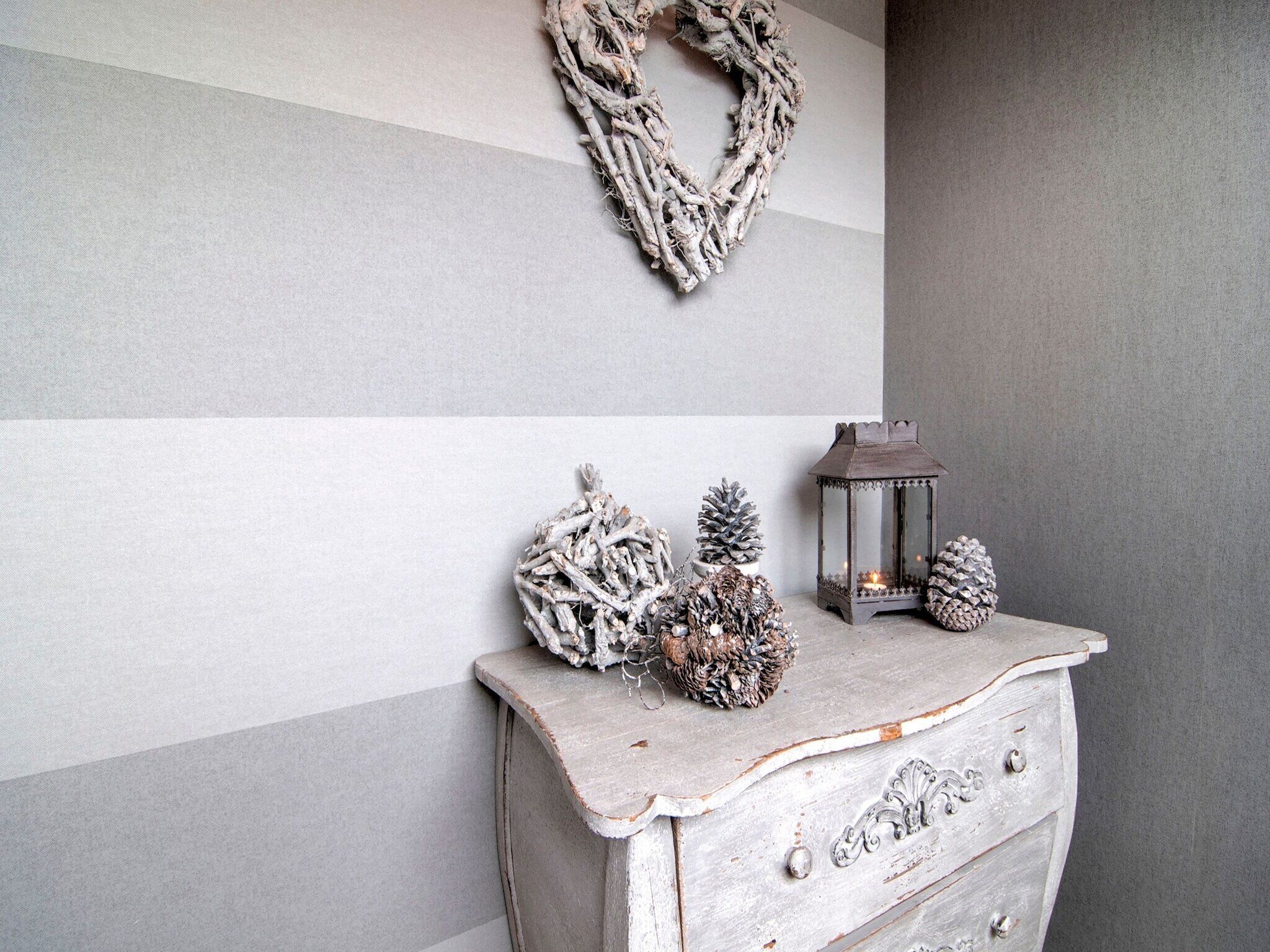 A rustic dresser with decorative pinecones and a lantern.