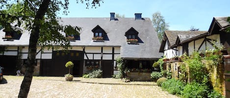 A traditional building with a cobblestone courtyard, wooden beams, and flower boxes on the windows.
