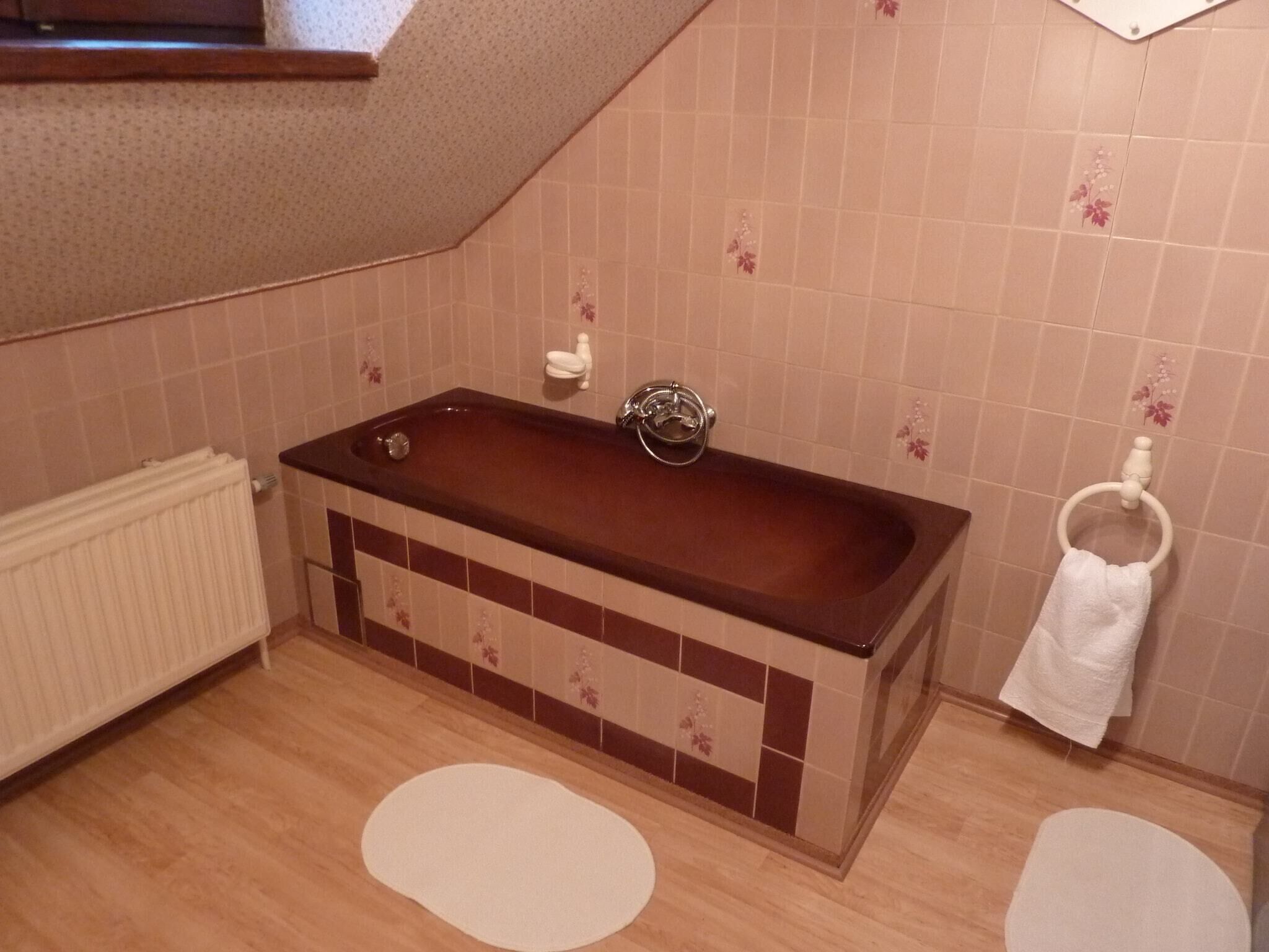Een badkamer met een bad, een handdoekhouder en een radiator.