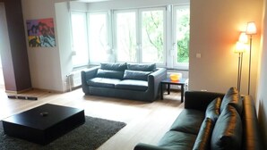 A modern living room with a sofa, a coffee table, and a lamp. - Eco Hilltop Home in Falaën (Falaën)