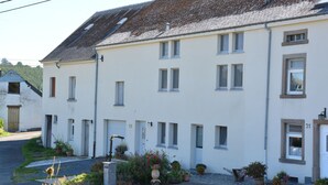 A two-story building with a white facade, multiple windows, and a sloped roof. - Nature Escape in Martelange (Martelange (radelange))
