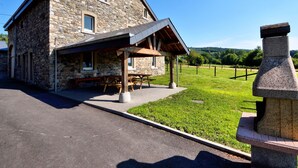 A stone building with a covered patio and picnic tables. - Charming Home in Ardennes (Petit-Thier)